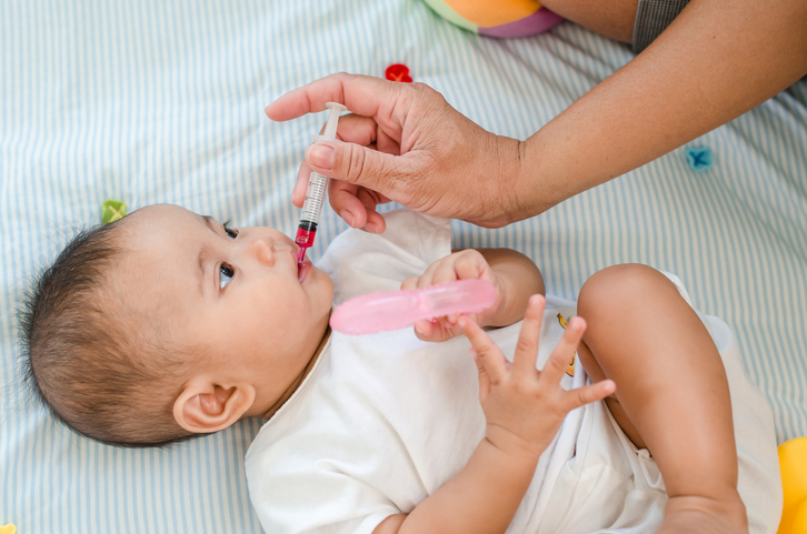 Baby being administered oral medication.