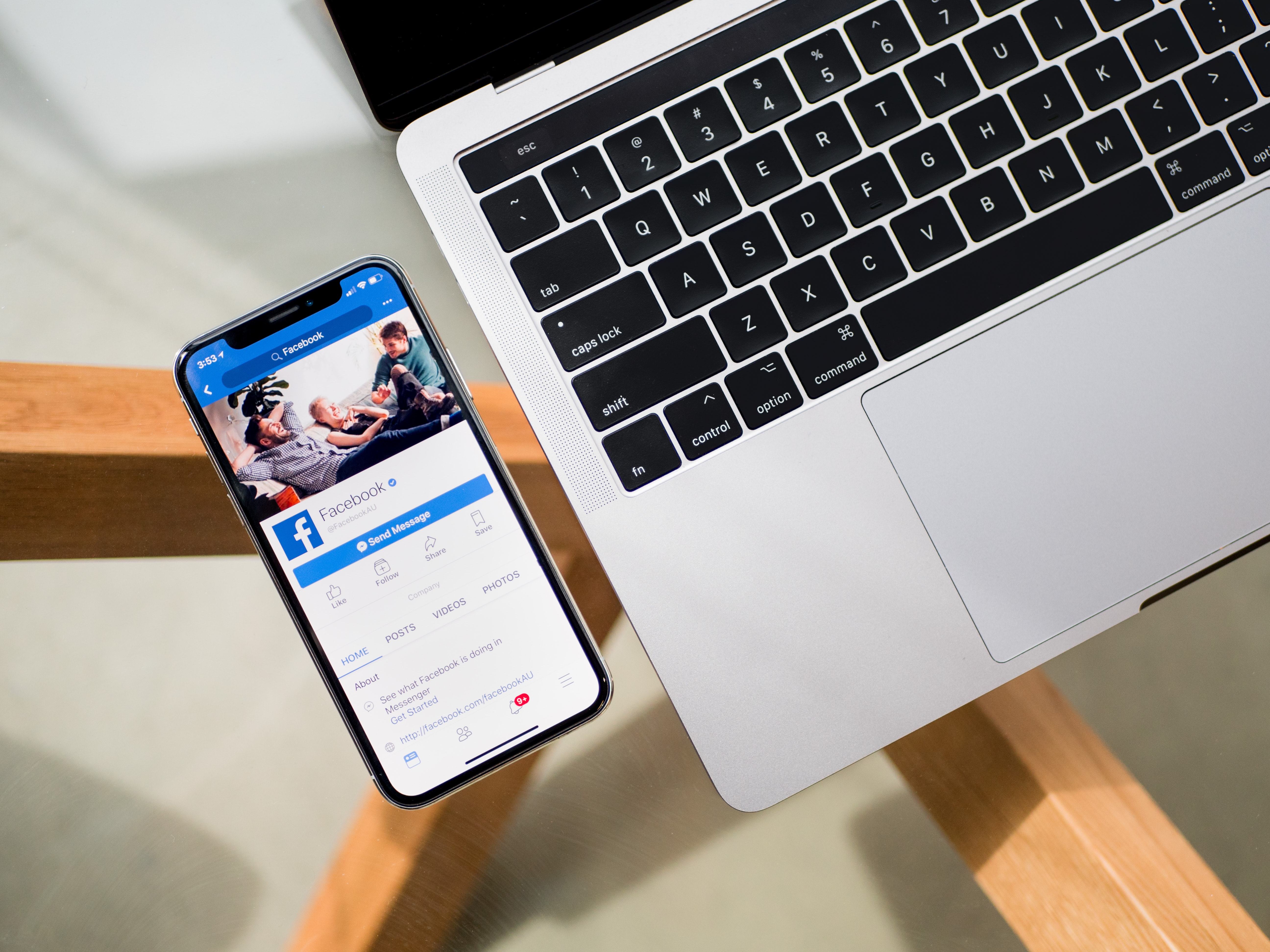 Close up of a phone and computer with Facebook loaded